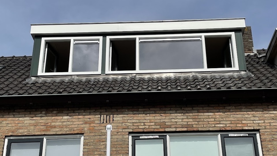 Dakkapel met drie ramen op een pannendak van een rijtjeswoning